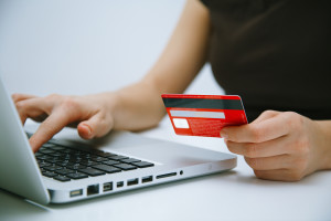 Mujer frente al ordenador pagando online con su tarjeta de crédito